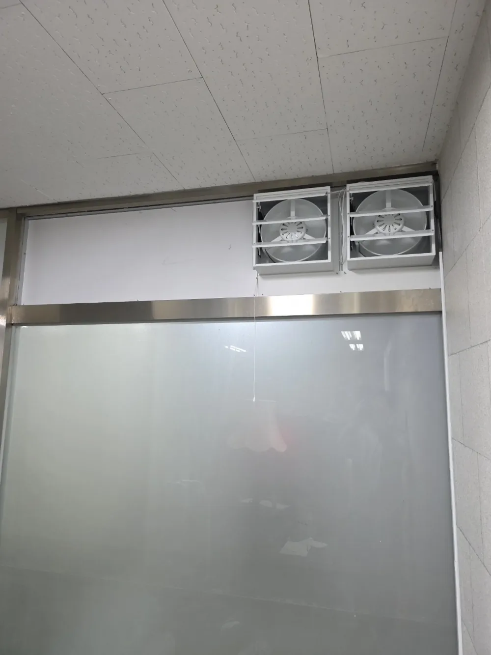 환풍기 설치 후, 유리 칸막이 위쪽에 환풍기 두 대를 나란히 단 모습